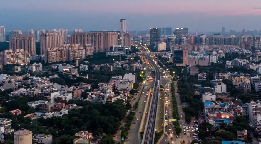 An aerial dusk view of Golf Course Extension Road with residential towers on either side