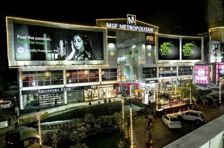 MGF Metropolitan Mall lit up at night on MG Road, Gurgaon, with Shoppers Stop and PVR Cinemas